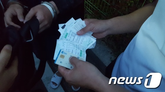 경찰이 보이스피싱 조직에게 범죄피해금을 전달하던 김모씨(24)로부터 압수한 무통장 입금표와 타인 명의로 된 현금카드.(부산지방경찰청 제공)© News1