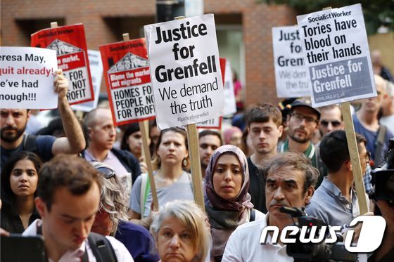 16일(현지시간) 런던 중심가에서 시민들이 '그렌펠을 위한 정의'라고 적힌 피켓을 들고 시위하고 있다. © AFP=뉴스1