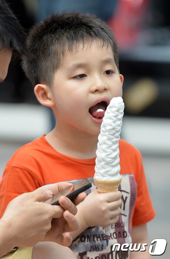 찜통더위가 8일째 이어진 23일 낮 어린아이가 아이스크림을 먹으며 더위를 식히고 있다. 2017.6.23/뉴스1 © News1 구윤성 기자
