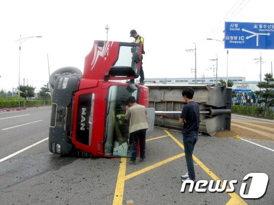 울산해경이 순찰 후 복귀하던 중 도로에 넘어진 트럭을 발견하고 운전자를 구조하고 있다. © News1