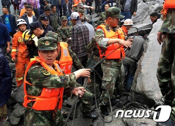 24일(현지시간) 중국 쓰촨성(四川省) 북서쪽 마오(茂)현에서 산사태가 발생해 군·경찰 등 구조인력이 수색 작업을 하고 있다. © AFP=뉴스1