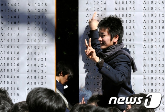 일본 도쿄대 앞에서 한 수험생이 대학 합격 여부를 확인하고 기뻐하고 있다. © AFP=뉴스1