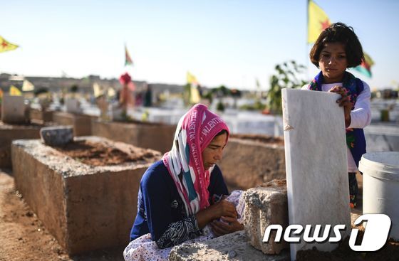 한 시리아 여성이 숨진 남편의 묘를 살피고 있다. © AFP=뉴스1