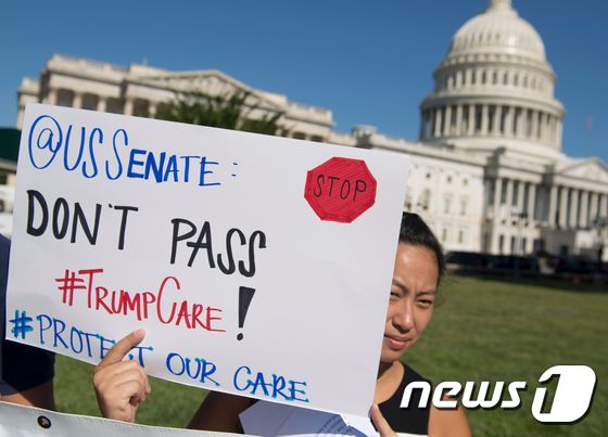 미국의 새 건강보험 개혁안인 미국보건법(AHCA), 이른바 '트럼프케어'에 반대하는 시민들이 의회 앞에서 피켓을 들고 있다. © AFP=뉴스1