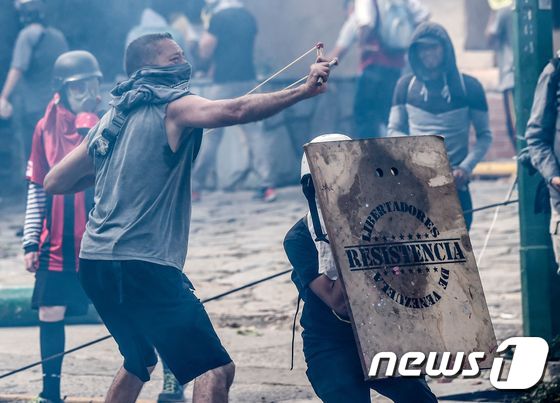 베네수엘라 카라카스에서 26일(현지시간) 경찰과 충돌하는 반정부 시위자들.© AFP=뉴스1