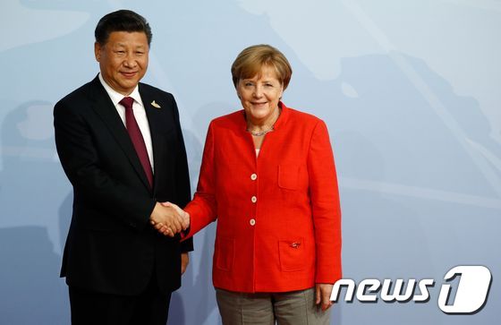 앙겔라 메르켈 독일 총리와 시진핑 중국 국가 주석이 지난해  함부르크 주요 20개국(G20) 정상회담에서 만나 악수를 하고 있다.  © AFP=뉴스1 © News1