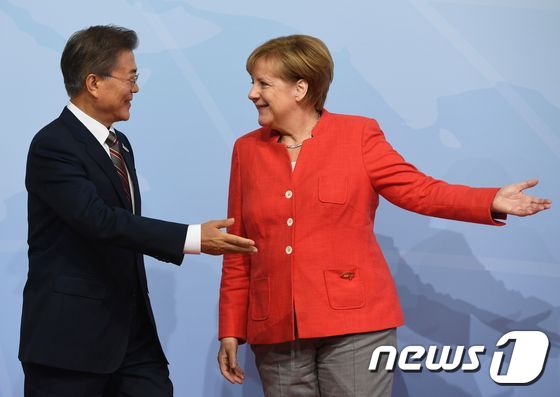앙겔라 메르켈 독일 총리(오른쪽)가 7일(현지시간) 함부르크 주요 20개국(G20) 정상회담 행사장에 도착한 문재인 대통령에게 자리를 안내하고 있다. © AFP=뉴스1 © News1 최종일 기자