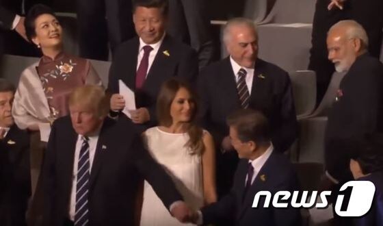 도널드 트럼프 미국 대통령이 7일(현지시간) 독일 함부르크 하펜시티에 있는 한 콘서트홀에서 문재인 대통령을 향해 손을 뻗어 악수하고 있다. 시진핑 중국 국가주석이 뒷줄에서 이 모습을 지켜보고 있다. (유튜브 화면 캡처) © News1
