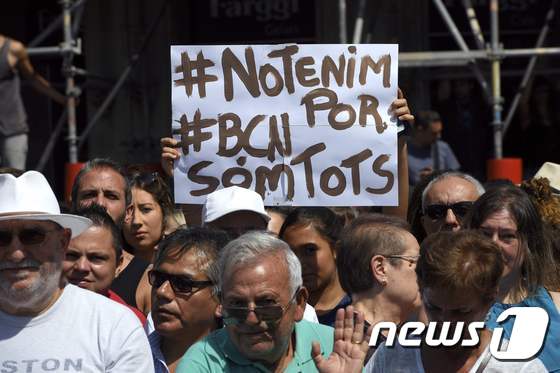 18일(현지시간) 바르셀로나 중심부에 위치한 카탈루냐 광장에서 열린 희생자 애도 행사에서 한 참석자가 '우리는 두렵지 않다'고 적힌 팻말을 들고 있다. © AFP=뉴스1