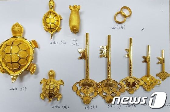 경찰이 피의자 숙소에서 발견하고 압수한 24k 황금열쇠와 황금거북이.(부산지방경찰청 제공)© News1