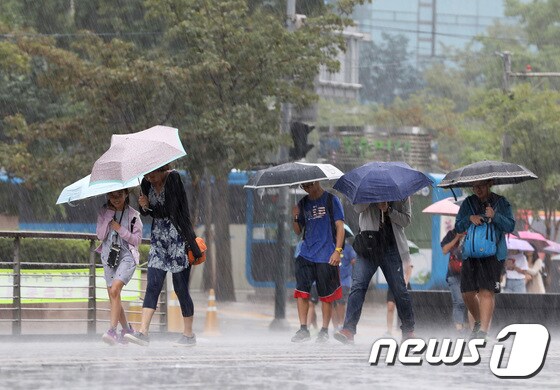 강한 비에 우산을 받쳐든 시민들이 서울 종로구 청계광장을 지나가고 있다.  © News1 이재명 기자