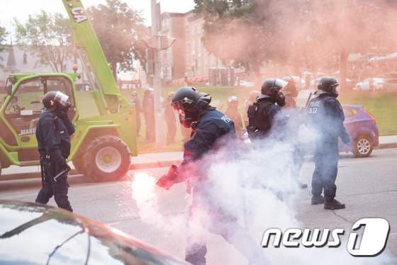 20일 캐나다 퀘벡주 퀘벡에서 반이민 집회와 이에 맞서는 맞불 시위대가 충돌해 경찰이 긴급 투입했다. © AFP=뉴스1
