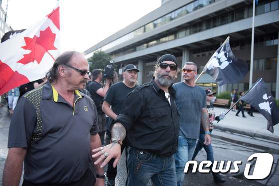 캐나다 국기를 흔들며 반이민을 부르짖는 극우단체 라 뭐트  © AFP=뉴스1