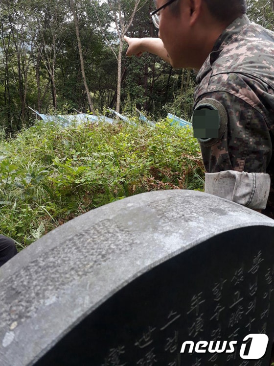 부대 관계자가 총탄 흔적 묘비에서 사격장 위치를 가리키고 있다. © News1 홍성우 기자