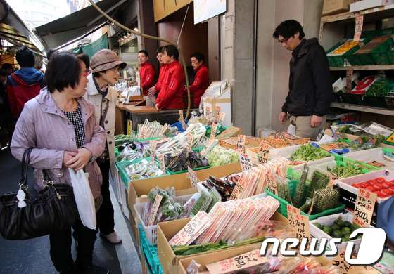 일본 도쿄의 쇼핑객들이 시장에서 채소를 살피고 있다. © AFP=뉴스1