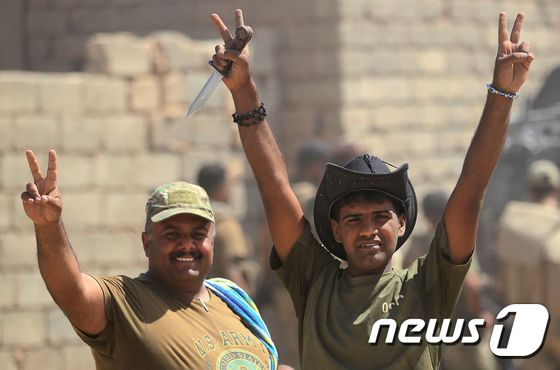 이라크군이 탈아파르 내 IS 최후 점령지를 향해 진군하다가 승리의 자세를 취하고 있다. © AFP=뉴스1