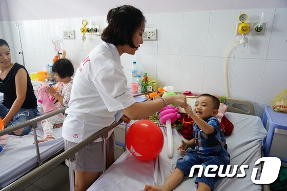 SK 대학생 자원봉사단원이 지난 4일 베트남 호치민시(市) 투득 병원에서 수술을 앞둔 아이들의 긴장을 풀기 위해 함께 시간을 보내고 있다.© News1