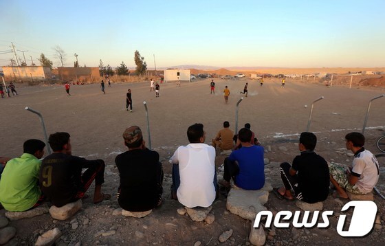 이라크 북부 도시 탈아파르에서 전쟁을 피해 도망친 청년들이 난민캠프에서 축구 경기를 보고 있다. © AFP=뉴스1