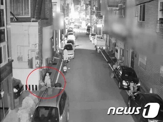 A씨(56)가 새벽시간에 경남 창원시 마산회원구의 한 길가에서 술에 취해 잠이든 여성에게 접근해 금품을 훔치고 있다.(경남경찰청제공)2017.8.9/뉴스1© News1