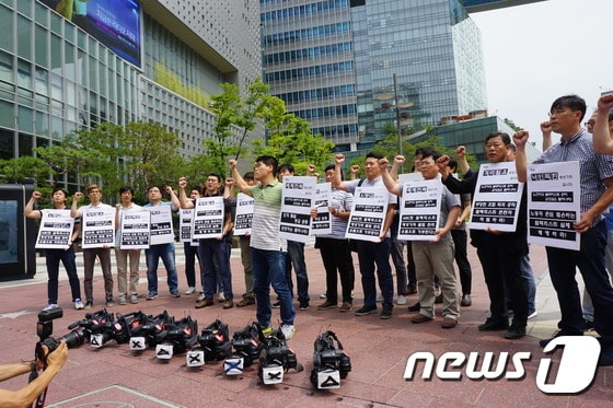 MBC 영상기자회 소속 카메라기자들이 8일 오전 서울 마포구 상암MBC미디어센터 앞에서 '블랙리스트 문건' 관련 회사를 규탄하는 집회를 하고 있다. (전국언론노조 MBC본부 제공)© News1