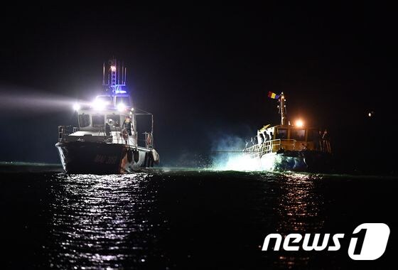 13일(현지시간) 루마니아 해안경비선(왼쪽) 난민보트를 끌고 흑해 연안에 위치한 루마니아 나보다리로 이동하고 있다. © AFP=뉴스1