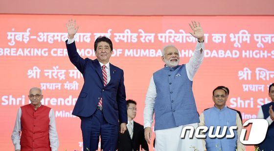 아베 신조 일본 총리(왼쪽)와 나렌드라 모디 인도 총리(오른쪽)이 14일(현지시간)  인도 아마다바드에서 열린 고속철도 기공식에 참석해 손을 흔들며 인사하고 있다. © AFP=뉴스1