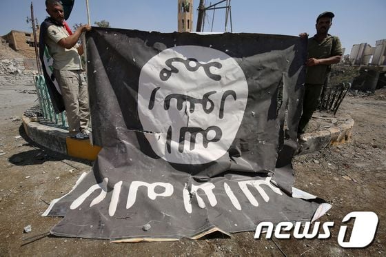 이슬람국가(IS) 국기를 펼치고 있는 이라크 민병대. © AFP=뉴스1