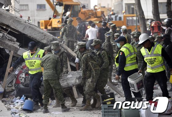 19일(현지시간) 규모 7.1의 강진이 덮친 멕시코 수도 멕시코시티에서 군인과 경찰·소방대원 등으로 구성된 구조대가 생존자 수색·구조 및 피해 복구 작업을 벌이고 있다. © AFP=뉴스1
