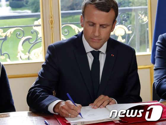 에마뉘엘 마크롱 프랑스 댙오령이 22일 엘리제궁 집무실에서 노동법을 개정을 위한 행정명령에 서명하고 있다. © AFP=뉴스1