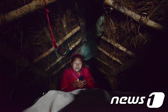생리 중 격리되는 '차우파디' 관습에 따라 오두막에서 밤을 보내고 있는 네팔의 한 여성. © AFP=뉴스1