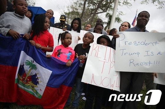 미 플로리다주 마이애미에서 12일 아이티 대지진 8주년 추모 행사에 참석한 시민들이 트럼프 대통령의 잇단 인종차별적 발언에 항의했다.  © AFP=뉴스1
