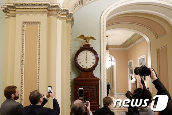 20일(현지시간 ) 미국 국회의사당의 시계가 12시(자정)을 가리키고 있다. © AFP=뉴스1