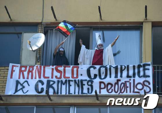 16일(현지시간) 프란치스코 교황이 방문한 칠레 수도 산티아고의 한 주택가에서 '프란치스코는 소아성애 범죄의 공범'이라고 적힌 플랜카드가 걸려 있는 모습. © AFP=뉴스1