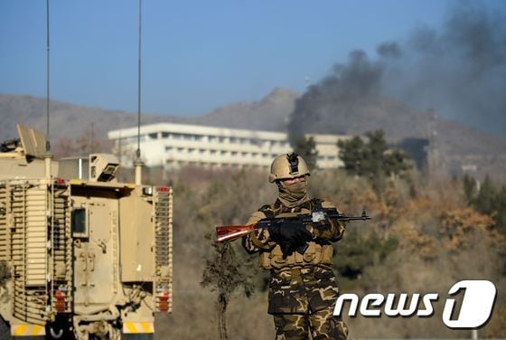 아프가니스탄 군인이 21일(현지시간) 탈레반 총기 테러가 발생한 카불 인터컨티넨탈 호텔 앞에 서 있다. © AFP=뉴스1