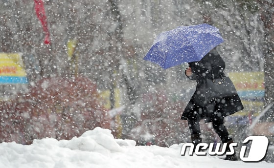 오후에도 전북지역에 눈이 내리다 그치다를 반복하고 있는 9일 전북 전주시 노송광장에서 한 시민이 우산으로 눈을 피하며 걸어가고 있다.2018.1.9/뉴스1 © News1 문요한 기자