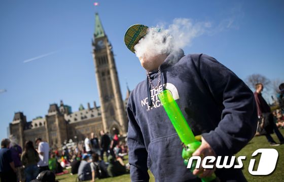 마리화나의 날을 맞아 한 남성이 캐나다 오타와의 의회 앞에서 대마초를 피우고 있다. © AFP=뉴스1