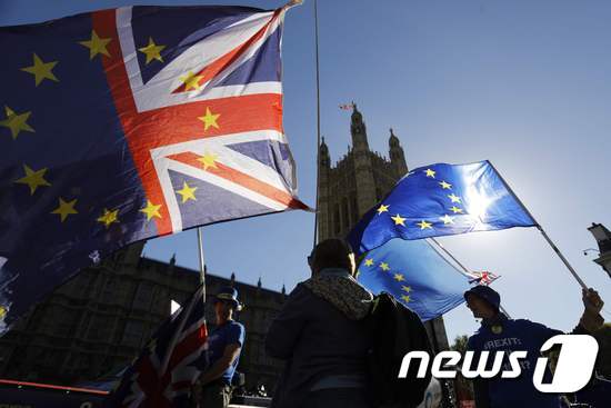 영국 런던 의회 광장에서 영국 국기와 유럽연합(EU)기를 들고 브렉시트에 반대하는 시위자들.<strong class=