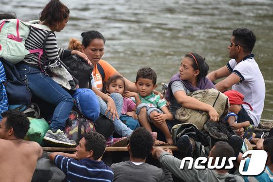 뗏목을 타고 강을 넘으려는 캐러반 행렬. © AFP=뉴스1