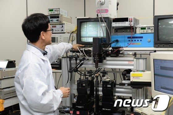 ETRI 김진태 박사가 이번에 개발된 광소자의 형상을 현미경으로 관찰하고 있다.© News1