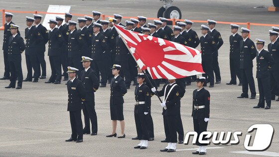 일본 해상자위대 소속 장병들이 욱일기를 들고 서 있다.© AFP=뉴스1 © News1