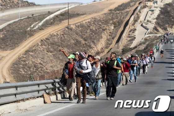 지난 13일(현지시간) 멕시코 북서부 티후아나를 걷고 있는 중미 이민자 행렬. © AFP=뉴스1