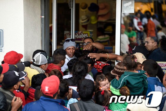 멕시코 소노라주 과이마스의 상점으로 들어가려는 중미 출신 이민자 행렬.  © AFP=뉴스1
