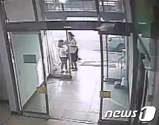 CCTV에 잡힌 A씨가 한 학원 건물에서 초등학생에게 접근해 머리를 털어주며 금목걸이를 빼내는 모습 /사진제공=남양주경찰서 © News1