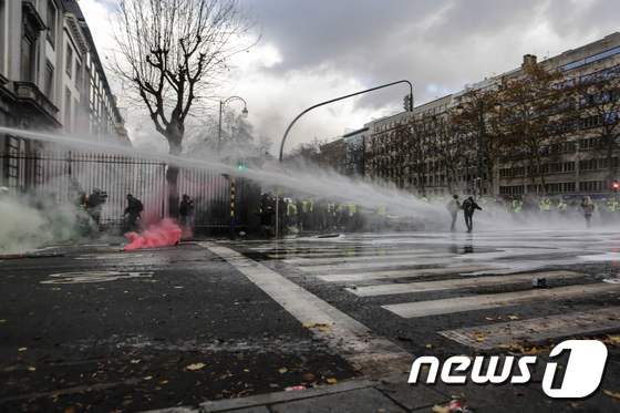 지난달 30일(현지시간) 벨기에 브뤼셀에 있는 유럽연합(EU) 본부 건물 인근에서 경찰이 노란조끼 시위대를 향해 물대포를 쏘고 있다. © AFP=뉴스1