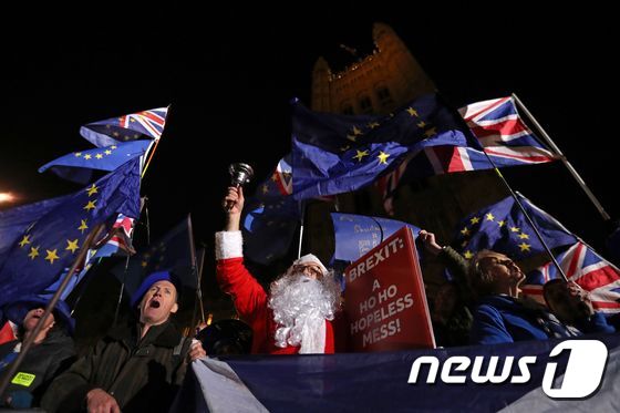 산타클로스 복장을 한 반(反)브렉시트 시위자가 11일(현지시간) 영국 런던 국회의사당 앞에서 시위를 벌이고 있다. © AFP=뉴스1
