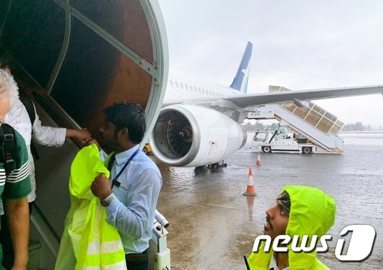 폭우에 승객들의 안전을 위해 안내를 돕고 있는 항공사 직원들 © News1 