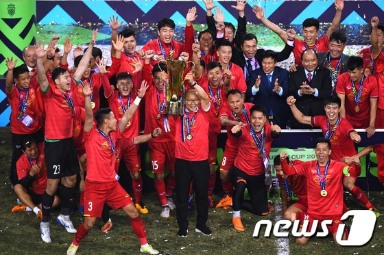 박항서 감독(가운데)이 지난해 12월15일(한국시간) 베트남 하노이의 미딩 국립경기장에서 2018 아세안축구연맹(AFF) 스즈키컵 우승 트로피를 들어 올리고 있다. © AFP=News1