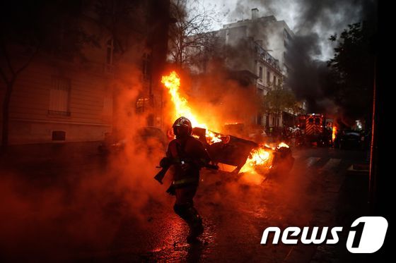 프랑스 노란조끼 시위 도중 발생한 차량 화재를 진압 중인 소방대원 © AFP=뉴스1