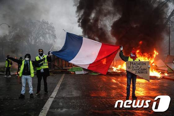 프랑스 노란조끼 시위 중 프랑스 국기를 든 시위 참가자들 © AFP=뉴스1