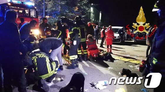 8일 오전 이탈리아 코리날도의 한 나이트클럽에서 압사사고가 발생해 구급대원들이 부상자를 옮기고 있다. © AFP=뉴스1